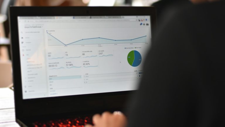 Marketer reviewing an analytics report on screen, representing Google Business Profile metrics now appearing inside Google Analytics.