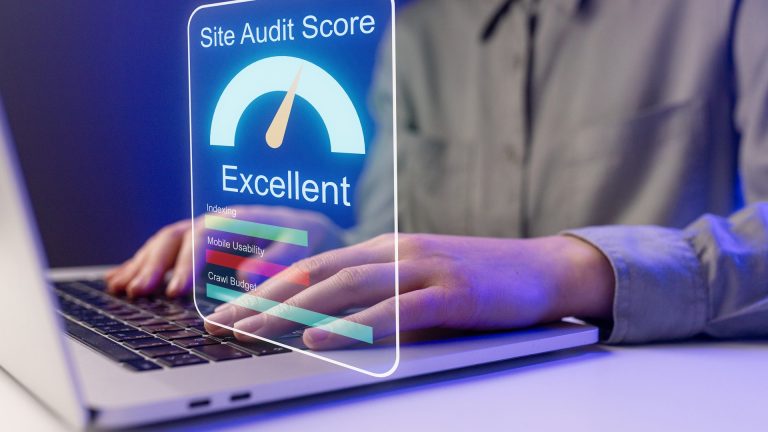 Small business owner checking a website audit score on a laptop at a workspace.