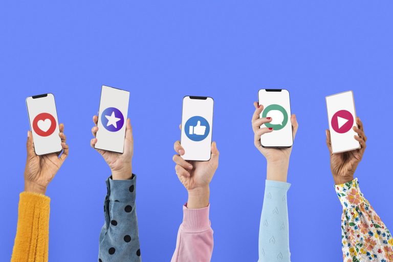 Five hands holding smartphones, each screen showing a different social media icon