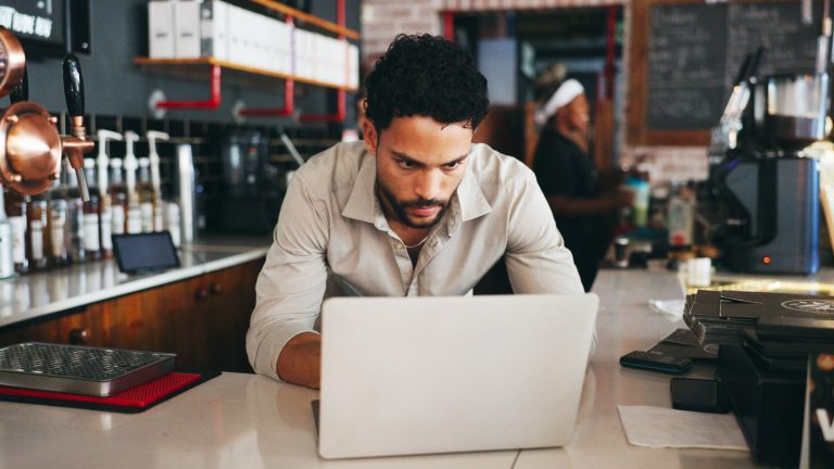 Small-business owner checking an account alert on a laptop