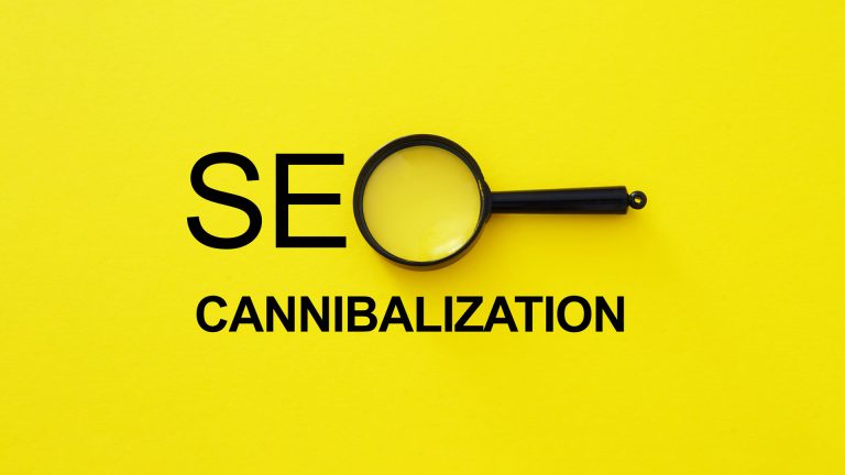 Magnifying glass over the words SEO cannibalization on a yellow background