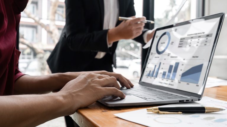 Business professionals reviewing performance charts on a laptop