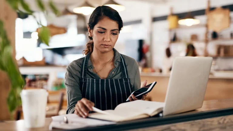 Small business owner reviewing a website update plan beside a laptop