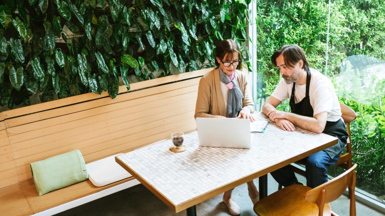 A small business owner at a laptop deciding which technical SEO skills are worth learning